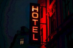 Ein Foto bei nacht von einer rot leuchtenden Tafel, auf der Hotel steht.