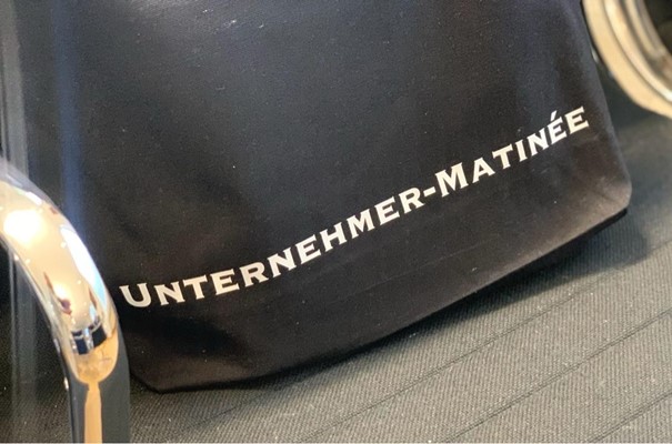 Tasche mit Schriftzug Unternehmermatinée auf einem Stuhl